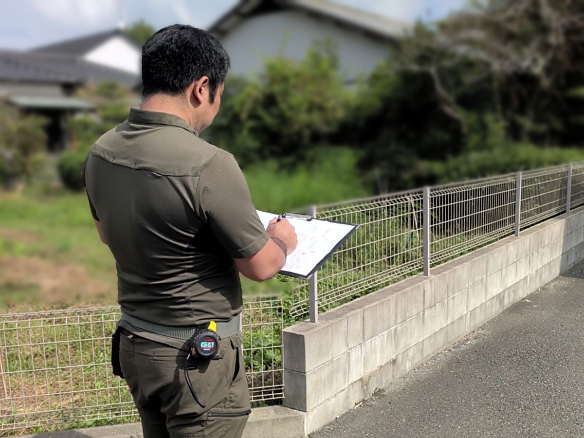 現地で資料に書き込みながら、土地の様子を確かめる土地家屋調査士